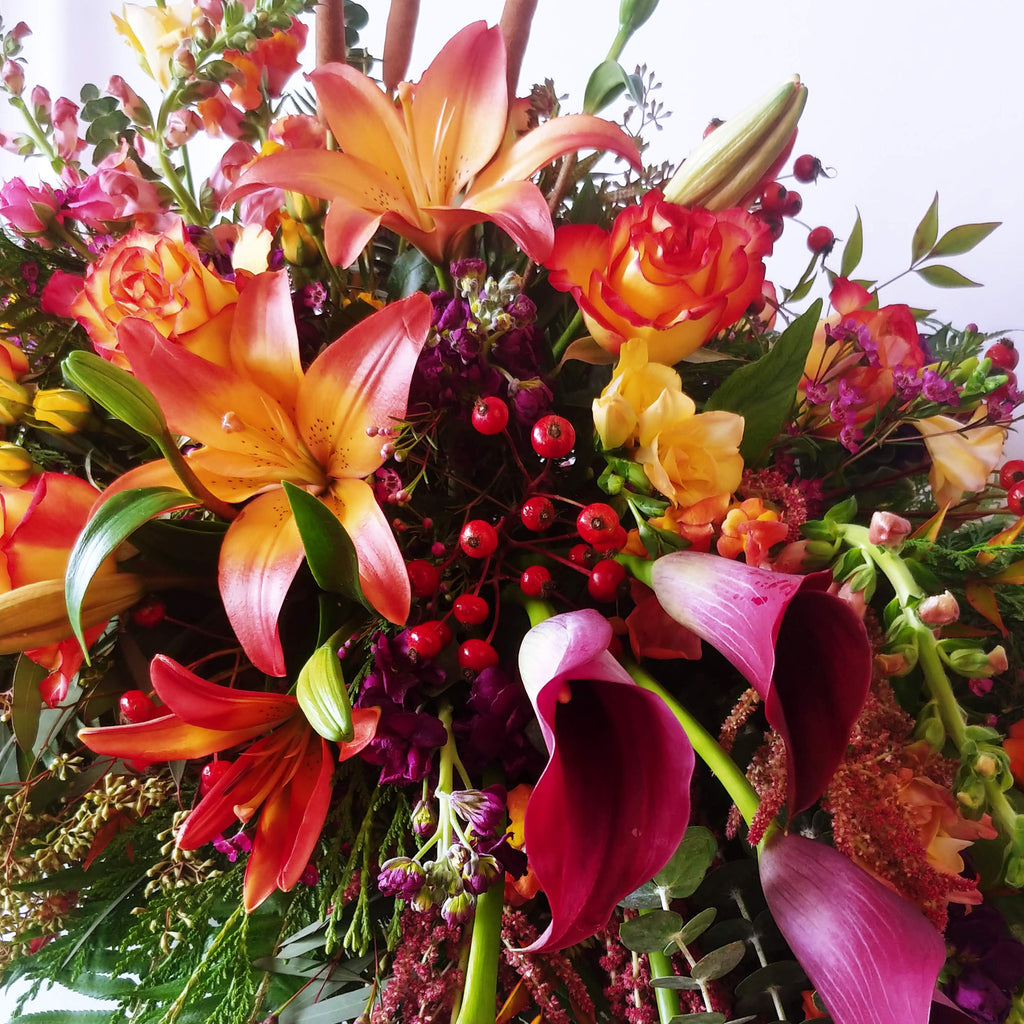 orange lilies, calla lilies, snap dragons, floral, flower arrangement, table arrangement, casket 
